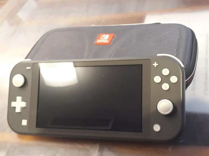 Nintendo Switch Lite Konsoli Harmaa Kaytetty Mukaan kuvassa oleva kotelo ja nintendon laturi